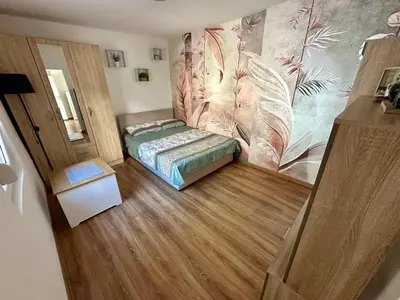 a bedroom with a bed in a room with wooden floors at The Old Town House in Belgrade