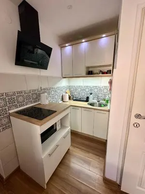 a small kitchen with white cabinets and a sink at The Old Town House in Belgrade