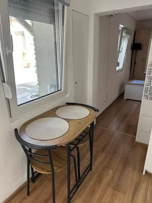 a table and chairs in a room with a window at The Old Town House in Belgrade