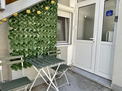 a green wall with two chairs next to a door at The Old Town House in Belgrade