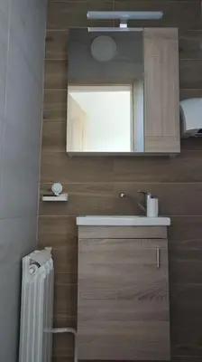 a bathroom with a sink and a mirror and a radiator at Vila Ruža Vetra in Belgrade