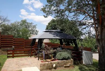 a patio with an umbrella in front of a fence at Vila Ruža Vetra in Belgrade