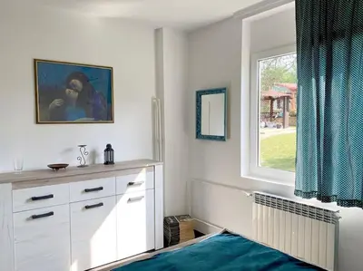 a white bedroom with a window and a dresser at Vila Ruža Vetra in Belgrade