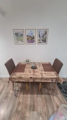 a dining room table with chairs and pictures on the wall at SAMITEST in Batajnica