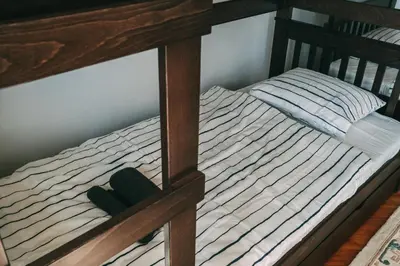 a wooden bunk bed with a green hat on it at Smart hostel in Belgrade
