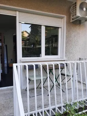 a porch with a white railing and a window at Smart hostel in Belgrade