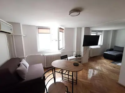 a living room with a couch and a table at Nov apartman u mirnoj ulici u centru Beograda in Belgrade