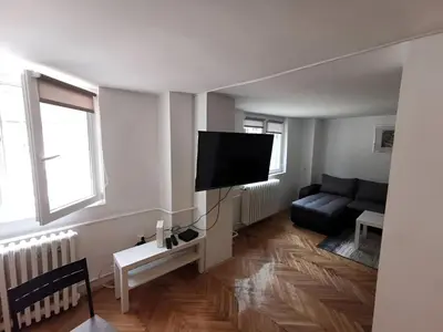 a living room with a couch and a flat screen tv at Nov apartman u mirnoj ulici u centru Beograda in Belgrade