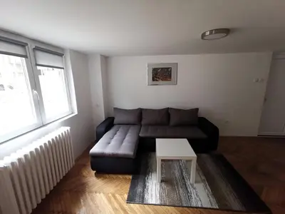 a living room with a couch and a table at Nov apartman u mirnoj ulici u centru Beograda in Belgrade
