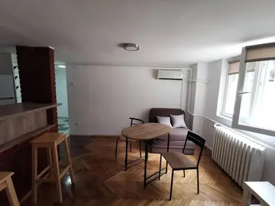 a room with a table and chairs in a room at Nov apartman u mirnoj ulici u centru Beograda in Belgrade