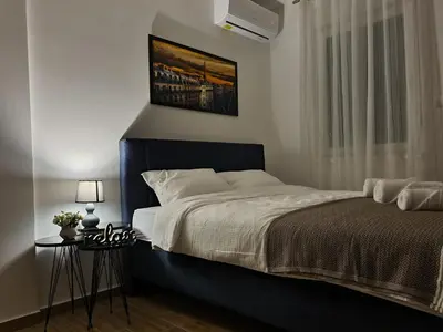 a bedroom with a large bed and a window at Stella Apartman Ruma in Ruma
