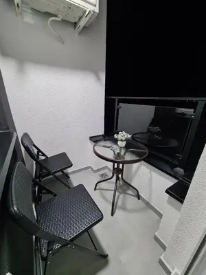 a room with two chairs and a table and a tv at Stella Apartman Ruma in Ruma