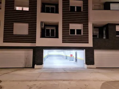 a building with a door in the middle of a street at Stella Apartman Ruma in Ruma
