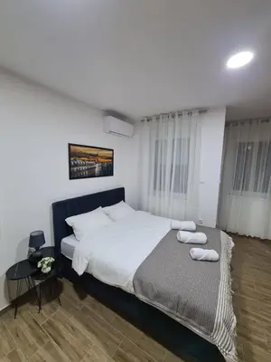 a bedroom with a bed and a table with towels on it at Stella Apartman Ruma in Ruma