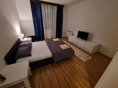a bedroom with a large bed and a couch at Maksim in Vračar (historical)