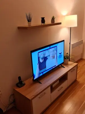 a flat screen tv sitting on top of a entertainment center at Maksim in Vračar (historical)