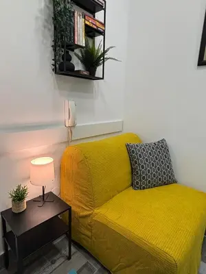 a yellow couch in a living room with a table at So Cozy in Belgrade