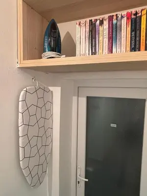 a book shelf above a door with books at So Cozy in Belgrade