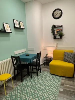 a living room with a yellow couch and a table at So Cozy in Belgrade
