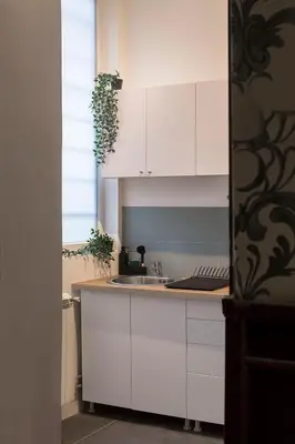 a kitchen with white cabinets and a sink at High Note Apartment in Belgrade