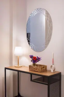a table with a mirror and a lamp and flowers at High Note Apartment in Belgrade