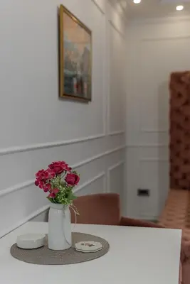 a table with a vase with flowers on it at TIMS Apartman 7 in Belgrade