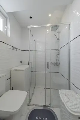 a white bathroom with a shower and a toilet at TIMS Apartman 7 in Belgrade