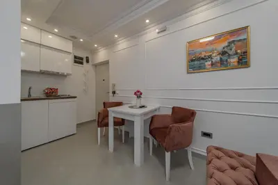 a living room with a white table and chairs at TIMS Apartman 7 in Belgrade