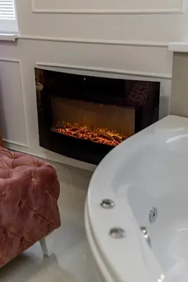 a bathroom with a white toilet and a fireplace at TIMS Apartman 7 in Belgrade