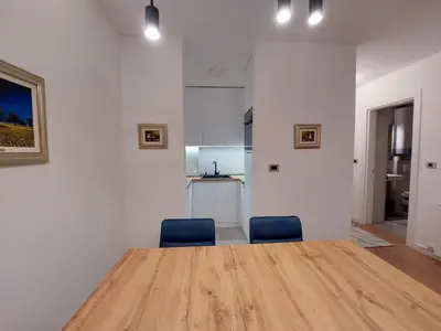 a room with a wooden table and two blue chairs at Apartment West 65 in Belgrade
