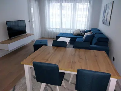 a living room with a table and a blue couch at Apartment West 65 in Belgrade