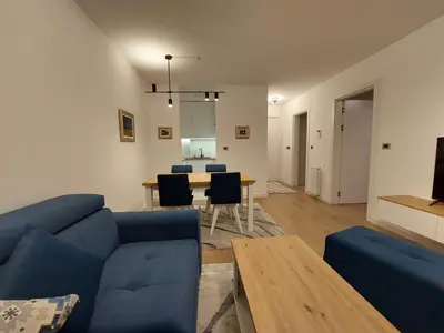 a living room with a blue couch and a table at Apartment West 65 in Belgrade