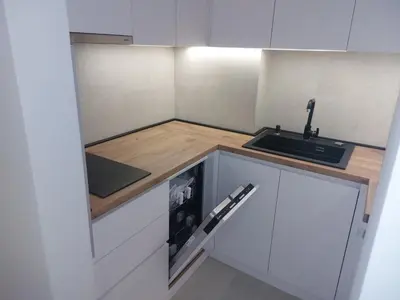 a small kitchen with white cabinets and a sink at Apartment West 65 in Belgrade