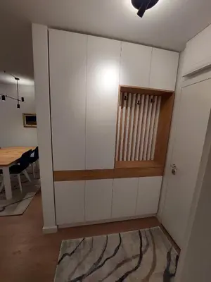 a large white cabinet in a room with a table at Apartment West 65 in Belgrade