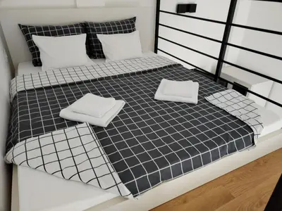 a black and white bed with two white towels on it at BEL GALLERIES ( Karadjordjeva street ) in Sajmište