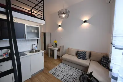 a small living room with a couch and a kitchen at BEL GALLERIES ( Karadjordjeva street ) in Sajmište