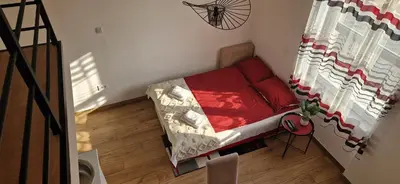 a small room with a red couch in a room at BEL GALLERIES ( Karadjordjeva street ) in Sajmište