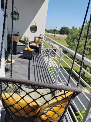a swing on a porch with a chair and a table at La Vista in Stari Banovci