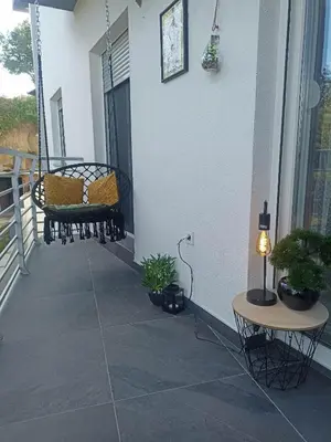 a porch with chairs and a table and plants at La Vista in Stari Banovci