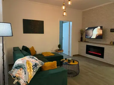 a living room with a green couch and a fireplace at La Vista in Stari Banovci