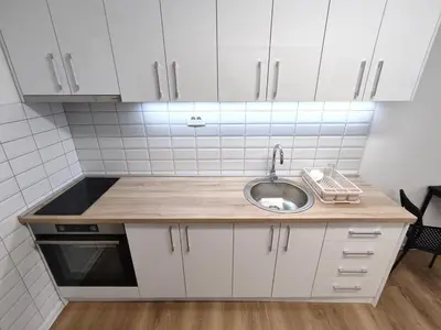 a small kitchen with a sink and white cabinets at Zarkovo in Belgrade