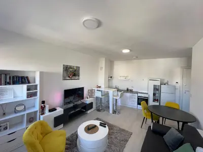 a living room with a table and yellow chairs at Belgrade Center Apartment Lux IV in Belgrade