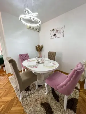a dining room with a white table and purple chairs at Elegant escape in Bele Vode