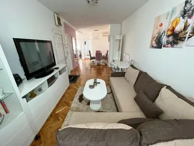 a living room with a couch and a tv at Elegant escape in Bele Vode