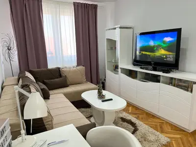a living room with a couch and a tv at Elegant escape in Bele Vode