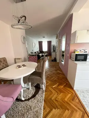 a living room and dining room with a white table and chairs at Elegant escape in Bele Vode