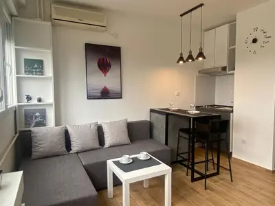 a living room and kitchen with a couch and a table at Apartment 55 Belgrade in Belgrade