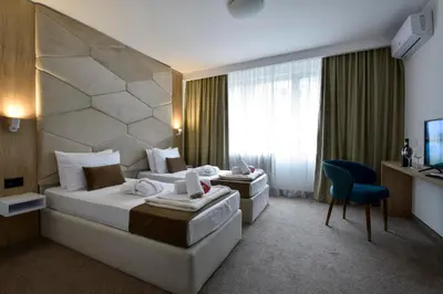 a hotel room with two beds and a television at Hotel Sumadija in Belgrade