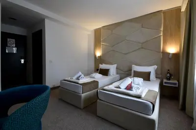 a hotel room with two beds and a couch at Hotel Sumadija in Belgrade