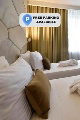 two twin beds in a hotel room with a sign that says free parking available at Hotel Sumadija in Belgrade